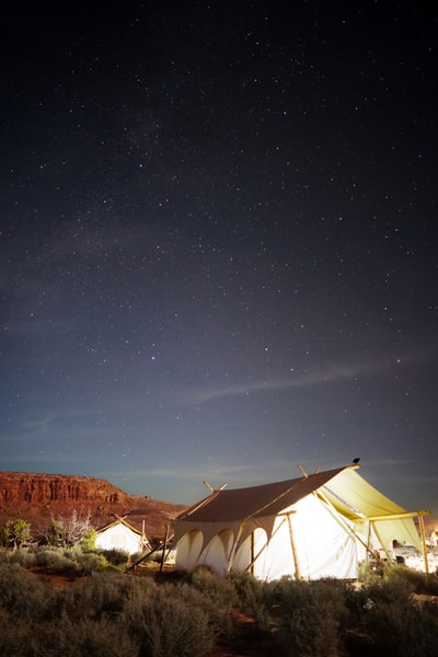 夜间露天场地上的白色小屋帐篷